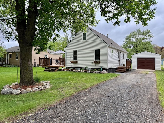 2728 Pine Ave, Slayton, MN 56172 - view of front of house with an outbuilding, a wooden deck, asphalt driveway, a garage, and a front yard