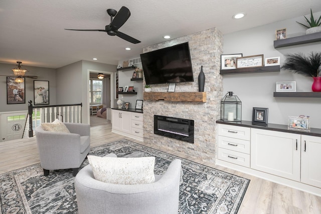 907 Rodeo Dr SE, Pine Island, MN 55963 - living area with ceiling fan, light wood finished floors, a fireplace, a textured ceiling, and recessed lighting