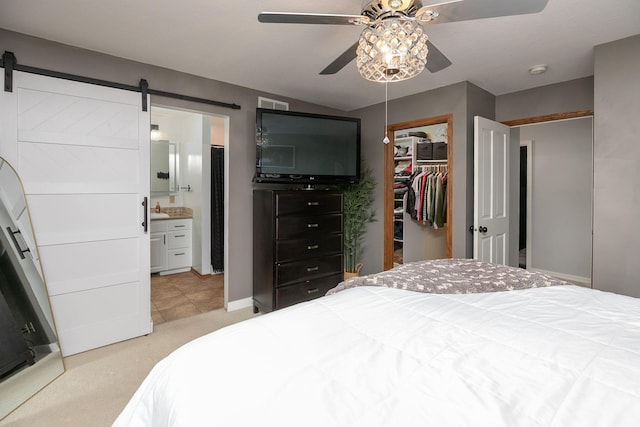907 Rodeo Dr SE, Pine Island, MN 55963 - bedroom with a walk in closet, light carpet, a barn door, a closet, and a sink