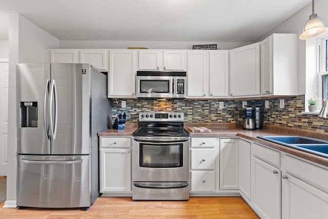 27385 Millicent Ln, Chisago Lake Twp, MN 55013 - kitchen featuring stainless steel appliances, white cabinetry, light wood finished floors, and a textured ceiling