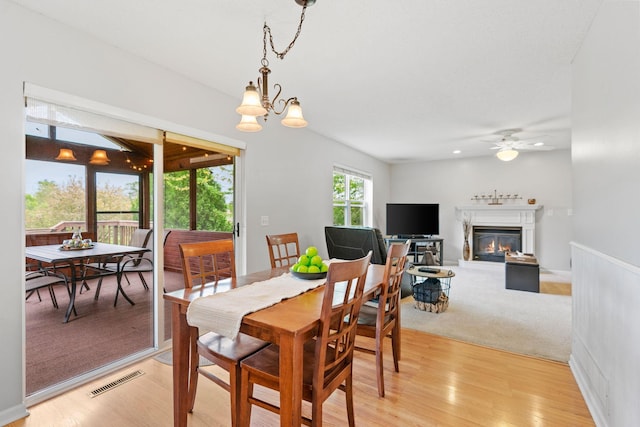 27385 Millicent Ln, Chisago Lake Twp, MN 55013 - dining room with a ceiling fan, a glass covered fireplace, and light wood-style flooring