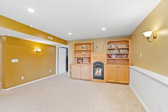 27385 Millicent Ln, Chisago Lake Twp, MN 55013 - unfurnished living room with a glass covered fireplace, light carpet, a wainscoted wall, and recessed lighting