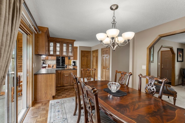 500 Mackubin Cir, Shoreview, MN 55126 - dining space featuring a chandelier, arched walkways, and a textured ceiling