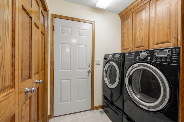 500 Mackubin Cir, Shoreview, MN 55126 - laundry room featuring washing machine and dryer, cabinet space, light tile patterned floors, a textured ceiling, and baseboards