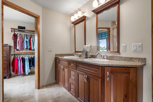 500 Mackubin Cir, Shoreview, MN 55126 - full bath featuring double vanity, a textured ceiling, a walk in closet, and baseboards