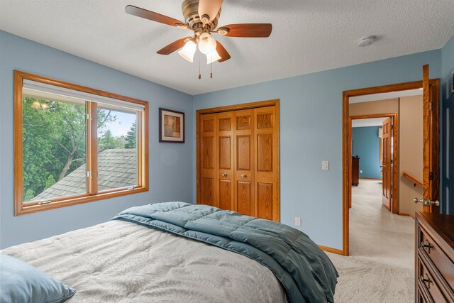 500 Mackubin Cir, Shoreview, MN 55126 - bedroom with light carpet, a closet, a ceiling fan, a textured ceiling, and baseboards