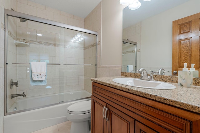 500 Mackubin Cir, Shoreview, MN 55126 - bathroom featuring vanity, toilet, combined bath / shower with glass door, tile patterned flooring, and tile walls