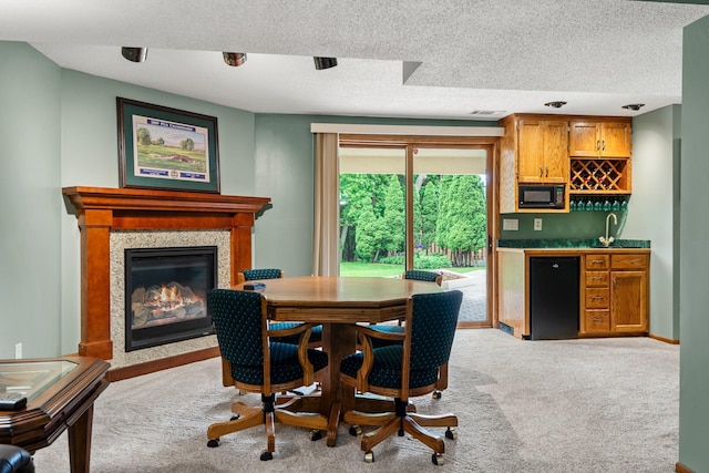 500 Mackubin Cir, Shoreview, MN 55126 - carpeted dining room featuring bar with sink, a premium fireplace, a textured ceiling, and baseboards