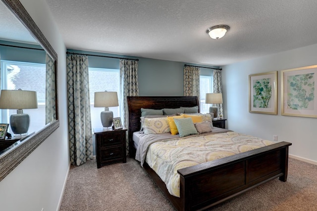 carpeted bedroom with a textured ceiling and baseboards
