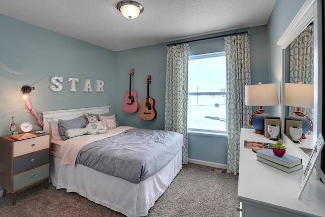 carpeted bedroom featuring baseboards and a textured ceiling