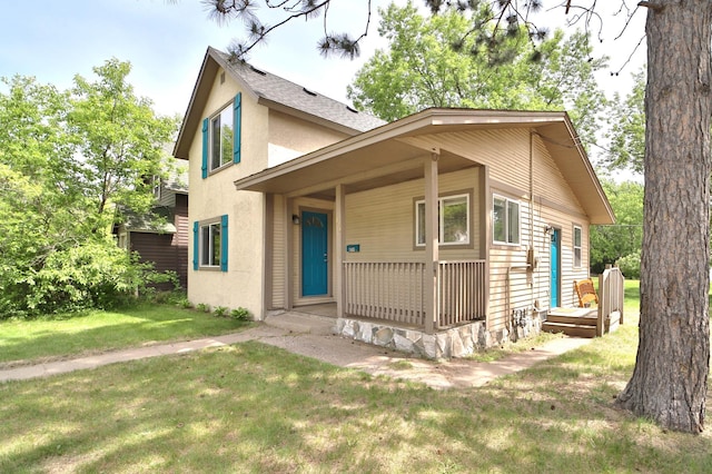 809 7th St, Brainerd, MN 56401 - view of front of house featuring stucco siding, a front yard, and covered porch