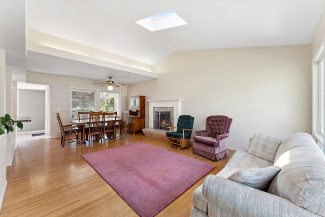 6300 Brooklyn Dr, Brooklyn Center, MN 55430 - living area with a tile fireplace, light wood finished floors, lofted ceiling, ceiling fan, and a skylight