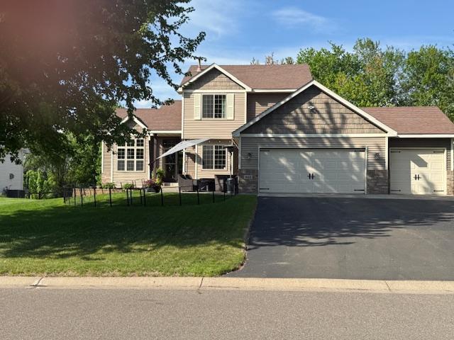 1523 155th Ln NW, Andover, MN 55304 - view of front facade with a garage, asphalt driveway, and a chimney