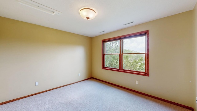 carpeted spare room featuring baseboards