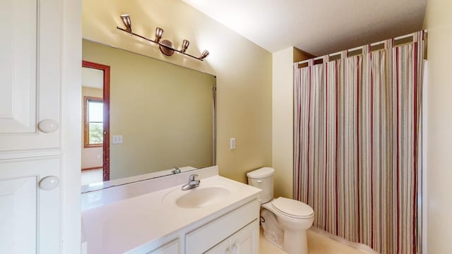 bathroom featuring toilet, vanity, and a shower with curtain