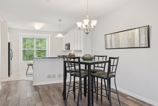 9675 Toledo Ln N, Brooklyn Park, MN 55443 - dining space featuring dark wood finished floors, a chandelier, and baseboards