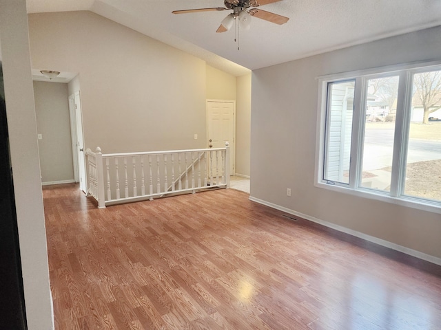 403 Littleford Ln, Faribault, MN 55021 - unfurnished room featuring vaulted ceiling, light wood-style floors, a ceiling fan, and baseboards