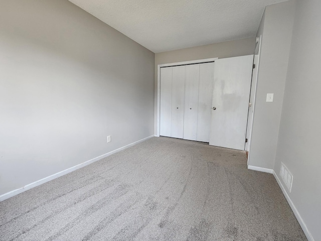 403 Littleford Ln, Faribault, MN 55021 - unfurnished bedroom with baseboards, carpet flooring, a closet, and a textured ceiling