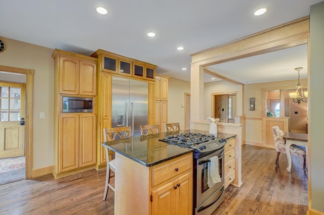 8632 Neal Ave S, Denmark Twp, MN 55033 - kitchen featuring built in appliances, light wood finished floors, dark stone countertops, glass insert cabinets, and recessed lighting