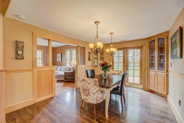 8632 Neal Ave S, Denmark Twp, MN 55033 - dining area featuring a chandelier, wood finished floors, ornate columns, and baseboards