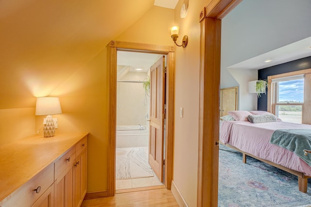 8632 Neal Ave S, Denmark Twp, MN 55033 - bedroom featuring vaulted ceiling, connected bathroom, light wood finished floors, and recessed lighting