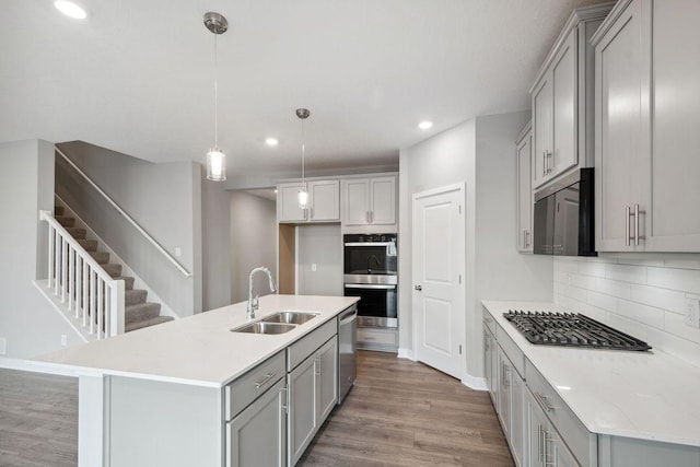 8397 Brumby Trl, Woodbury, MN 55129 - kitchen featuring a sink, appliances with stainless steel finishes, gray cabinets, wood finished floors, and recessed lighting