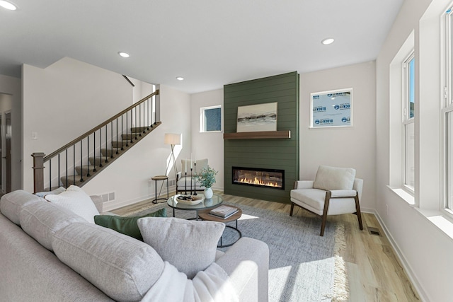 13430 Cadogan Way, Rosemount, MN 55068 - living room featuring wood finished floors, a large fireplace, stairs, recessed lighting, and baseboards
