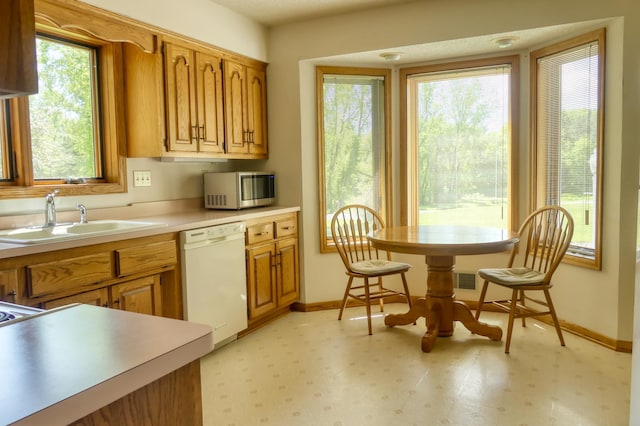 8790 212th St N, Forest Lake, MN 55025 - kitchen featuring white dishwasher, stainless steel microwave, a sink, and baseboards