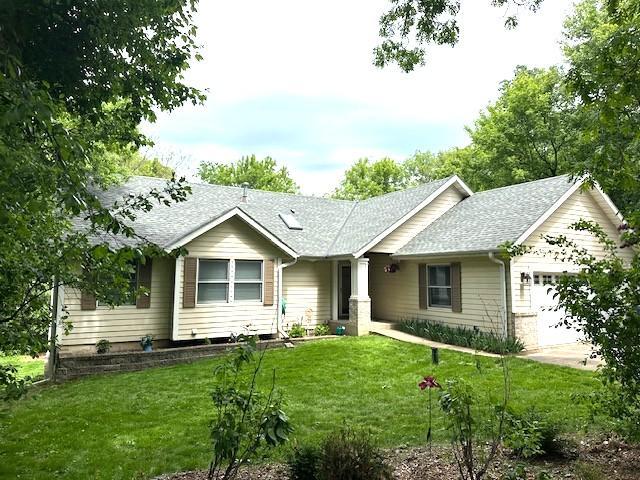 2211 Douglynn Ln, Saint Paul, MN 55119 - ranch-style home featuring a garage, roof with shingles, and a front lawn
