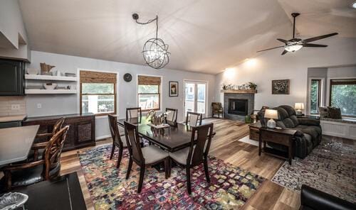 2211 Douglynn Ln, Saint Paul, MN 55119 - dining room featuring wood finished floors, a fireplace, healthy amount of natural light, a chandelier, and lofted ceiling