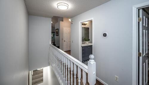 2211 Douglynn Ln, Saint Paul, MN 55119 - hallway featuring an upstairs landing, a textured ceiling, and baseboards