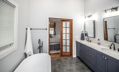 2211 Douglynn Ln, Saint Paul, MN 55119 - bathroom with french doors, double vanity, a soaking tub, and ensuite bath