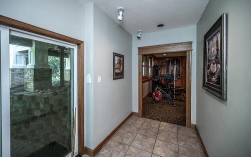 2211 Douglynn Ln, Saint Paul, MN 55119 - hallway with baseboards, a textured ceiling, and light tile patterned floors