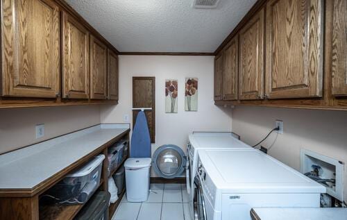 2211 Douglynn Ln, Saint Paul, MN 55119 - laundry area with cabinet space, independent washer and dryer, a textured ceiling, and light tile patterned floors