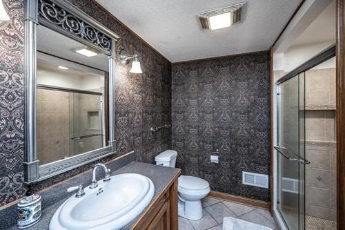 2211 Douglynn Ln, Saint Paul, MN 55119 - bathroom with wallpapered walls, vanity, toilet, a shower stall, and tile patterned flooring