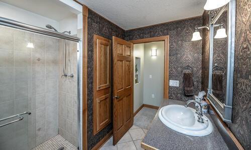 2211 Douglynn Ln, Saint Paul, MN 55119 - full bath featuring a shower stall, tile patterned floors, vanity, and a textured ceiling