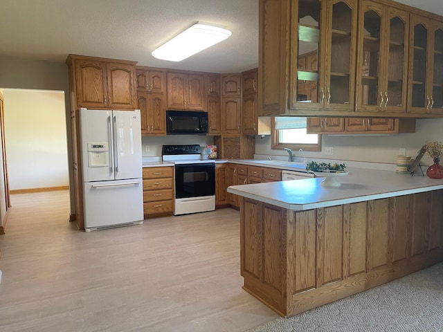 22 Jayvee Ln, Lake Sarah Twp, MN 56132 - kitchen with white fridge with ice dispenser, range with electric stovetop, black microwave, a peninsula, and brown cabinets
