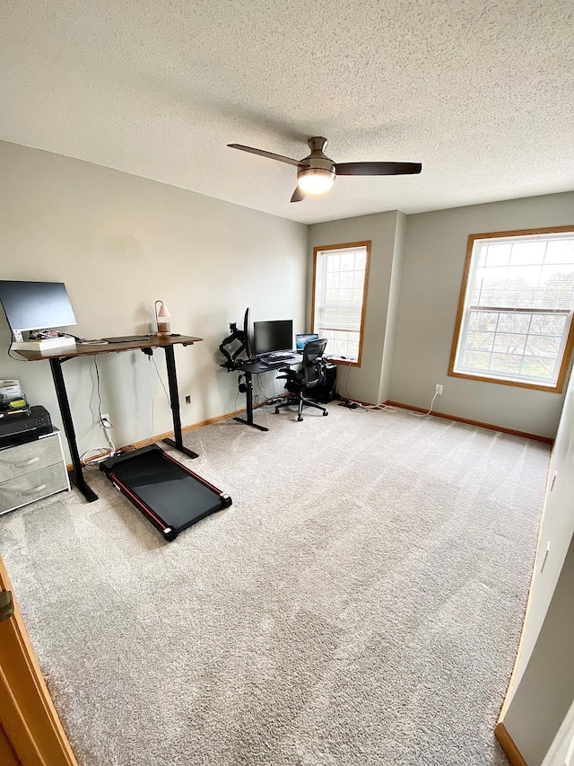 home office featuring carpet flooring, ceiling fan, baseboards, and a textured ceiling