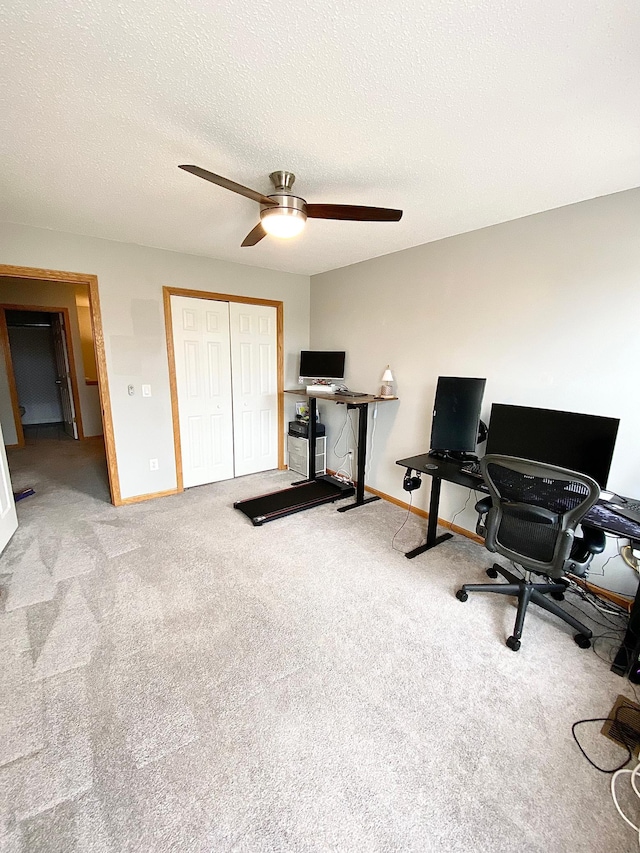 carpeted office featuring a ceiling fan, baseboards, and a textured ceiling