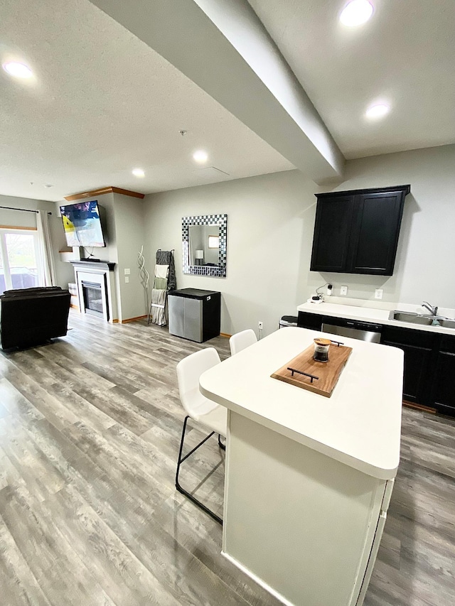 living area with light wood-type flooring, recessed lighting, baseboards, and a fireplace