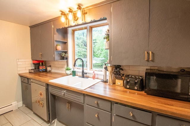 kitchen featuring butcher block countertops, a sink, black microwave, gray cabinets, and dishwashing machine