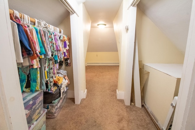 walk in closet featuring carpet floors, vaulted ceiling, and a baseboard heating unit
