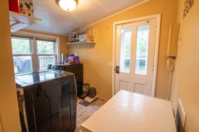 washroom featuring healthy amount of natural light, crown molding, baseboards, and washer and clothes dryer