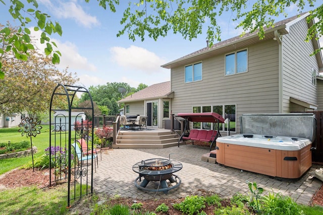 1665 Royal Oak Dr, Chaska, MN 55318 - rear view of house with a hot tub, an outdoor fire pit, a patio, and a wooden deck