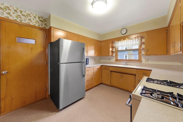 706 9th Ave SW, Faribault, MN 55021 - kitchen featuring freestanding refrigerator, wallpapered walls, white range with gas cooktop, and light countertops