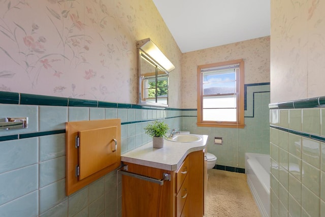 706 9th Ave SW, Faribault, MN 55021 - full bathroom featuring wallpapered walls, tile walls, toilet, a wainscoted wall, and vanity