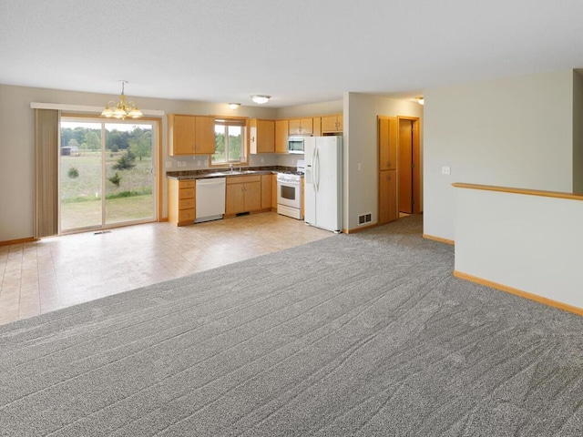 11023 171st Ave SE, Becker, MN 55308 - kitchen featuring white appliances, dark countertops, a sink, a chandelier, and baseboards