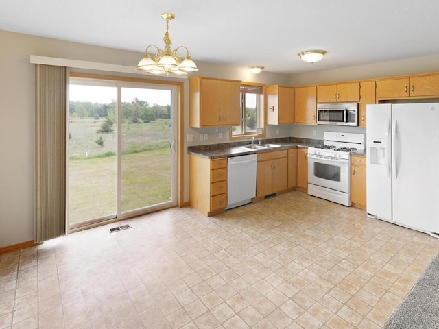 11023 171st Ave SE, Becker, MN 55308 - kitchen with white appliances, a sink, dark countertops, a chandelier, and hanging light fixtures