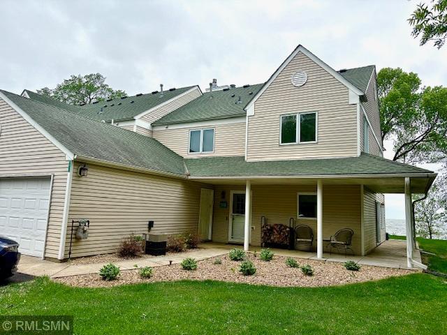 8012 Par Five Dr, South Harbor Twp, MN 56359 - view of front facade featuring an attached garage, covered porch, a front lawn, and cooling unit