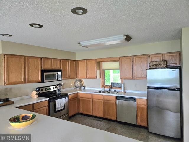 8012 Par Five Dr, South Harbor Twp, MN 56359 - kitchen featuring stainless steel appliances, a textured ceiling, light countertops, and a sink